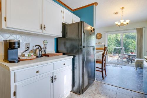 a kitchen with white cabinets and a stainless steel refrigerator at Pet-Friendly Wilmington Home with Fenced Yard! in Wilmington