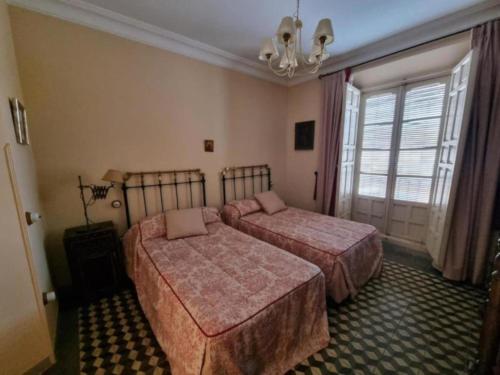 a hotel room with two beds and a window at El Granero de Manzanares in Manzanares