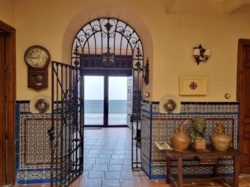 a room with an open door with a table and a clock at El Granero de Manzanares in Manzanares
