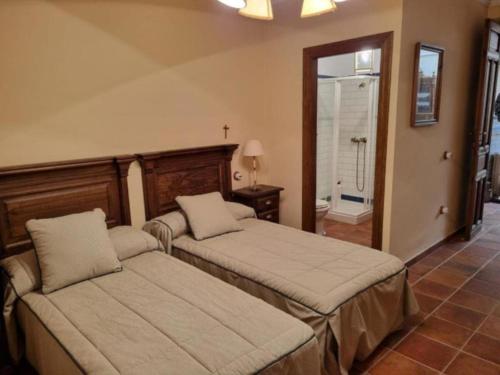 a bedroom with two beds and a bathroom at El Granero de Manzanares in Manzanares