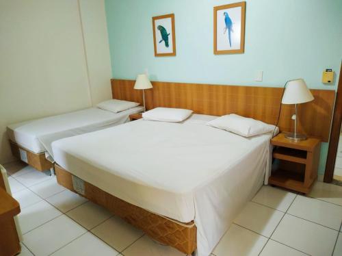 Un dormitorio con dos camas y una lámpara. en Golden Dolphin Grand Hotel piscinas 24h, en Caldas Novas