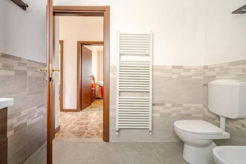 a bathroom with a white toilet and a hallway at Appartamento il vecchio Forno in Mercatale Val Di Pesa