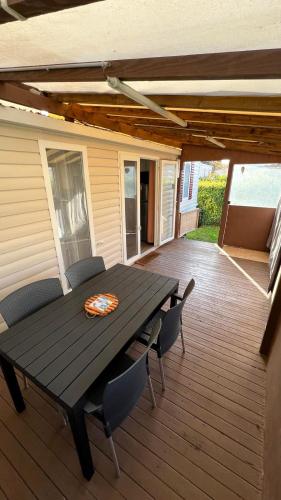 une terrasse en bois avec une table et des chaises dessus dans l'établissement Détente et nature au bord du Rhône, à Condrieu