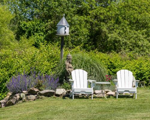 two chairs and a table in a yard with a lamp at Old Town Inn in New Shoreham