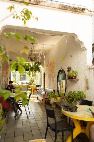 a room with tables and chairs and a mirror at Zili Pernambuco - Hostel Pousada in Recife