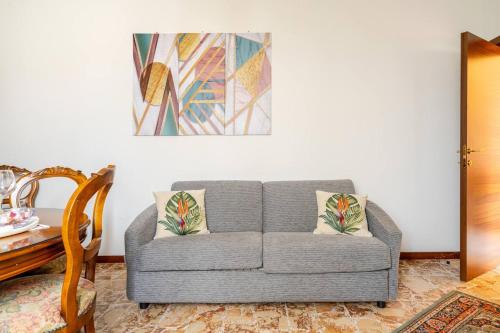 a living room with a gray couch and a table at Appartamento il vecchio Forno in Mercatale Val Di Pesa
