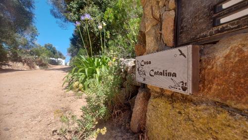a sign on the side of a stone building at Villa panoramica tra natura e relax a due passi mare in Cannigione