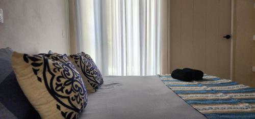 a bed with two pillows and auggage at Kin Tulum House downtown in Tulum