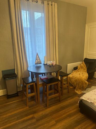 une pièce avec une table, des chaises et un lit dans l'établissement Appartement JOANNA, à Vittel