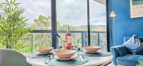 a table with a bottle of wine and two cups at Skyline Suites - Elegant Living with Coworking & Scenic Views in Bogotá
