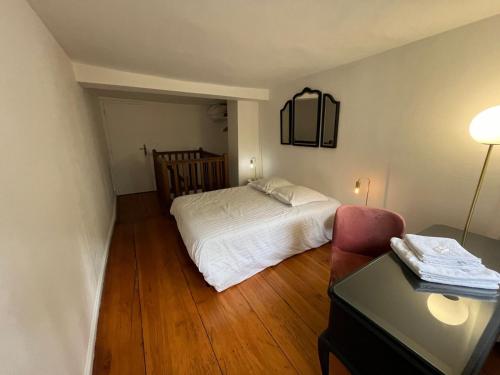 une petite chambre avec un lit et une chaise dans l'établissement Cosy Cathédrale, à Strasbourg