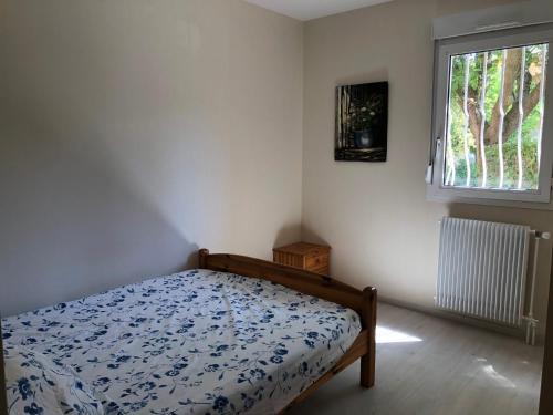 une chambre avec un lit et une fenêtre dans l'établissement Appartement dans quartier calme avec petit jardin, à Montpellier