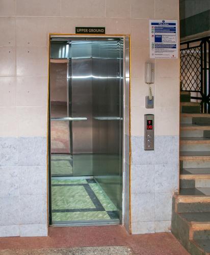 a metal elevator door in a building with stairs at Emerald-Zen Home in Ruaka