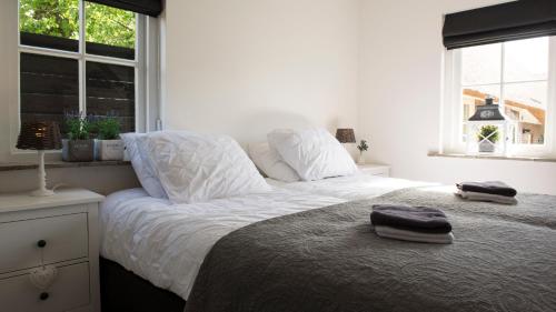 una camera da letto con un letto con due asciugamani sopra di Bed and Breakfast De Reggestee a Hellendoorn