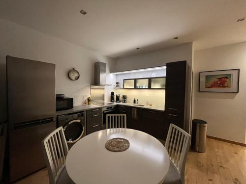 - une cuisine avec une table et une table et des chaises blanches dans l'établissement Appartement Loving You - Quartier Bonsecours, à Trouville-sur-Mer