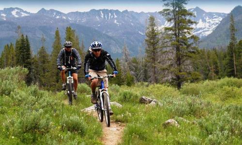 two people riding bikes on a trail in the mountains at Plush Mammoth Condo W Balcony Views in Mammoth Lakes