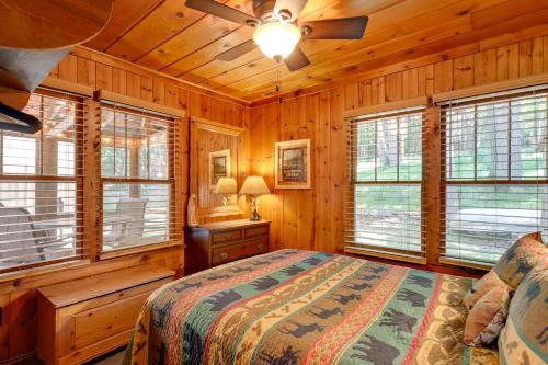 a bedroom with a bed and windows in a cabin at Quaint and Cozy Lake Cabin with Dock and Beach Access! in Sayner