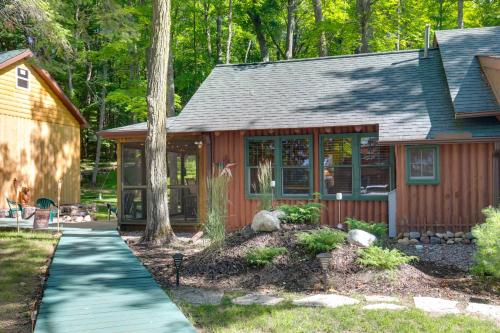 a small house with a walkway in front of it at Quaint and Cozy Lake Cabin with Dock and Beach Access! in Sayner