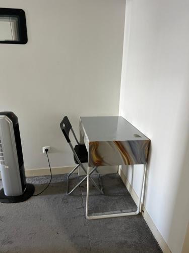 a desk and a chair next to a wall at São Lázaro Bhuiyan Family Host in Lisbon