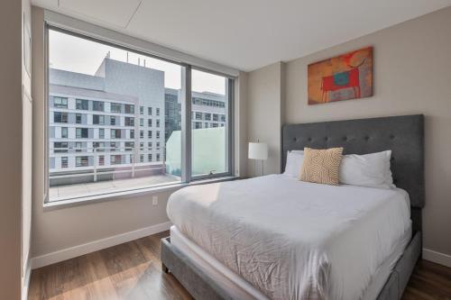 Un dormitorio con una cama y una ventana grande. en Private Apt Seaport with Gym, en Boston