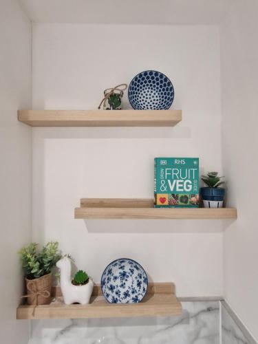 a shelf with two blue and white plates and a book at Apartment Near Wembley Stadium Heathrow London Barnet Luton Airport Hendon Middlesex University - FREE Parking & WiFi - Work Contractors & Tourists Welcome in Edgware