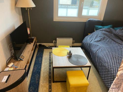 a small living room with a table and a couch at Ouitreham le Port-de-Mer in Ouistreham