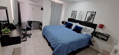 a bedroom with a bed with blue sheets and pillows at Casa en Puesta del Sol/Excelente Ubicación/2 Hab/Wifi/Netflix/Super comoda in Mérida