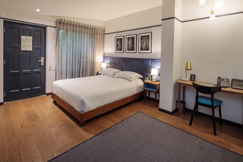 a bedroom with a bed and a desk and a table at HAB Hotel Bogotá in Bogotá
