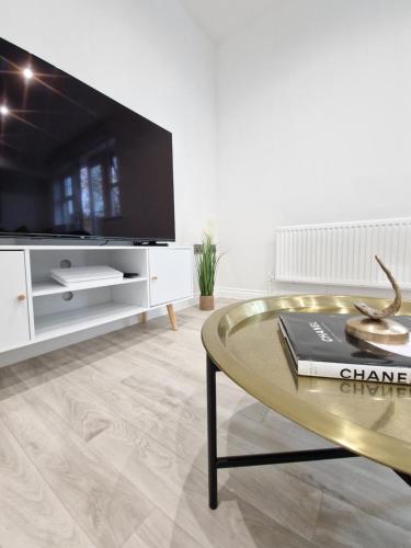 a living room with a tv and a coffee table at Apartment Near Wembley Stadium Heathrow London Barnet Luton Airport Hendon Middlesex University - FREE Parking & WiFi - Work Contractors & Tourists Welcome in Edgware
