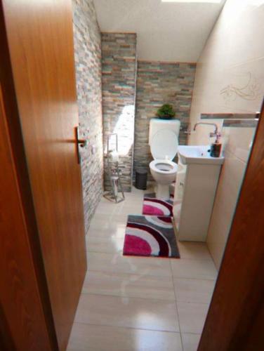 a bathroom with a toilet and a sink at Schönes Ferienhaus mit Pool in Biograd na Moru