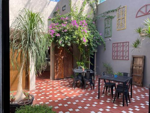 a courtyard with tables and chairs and flowers at Entre Patios Hotel Boutique in León