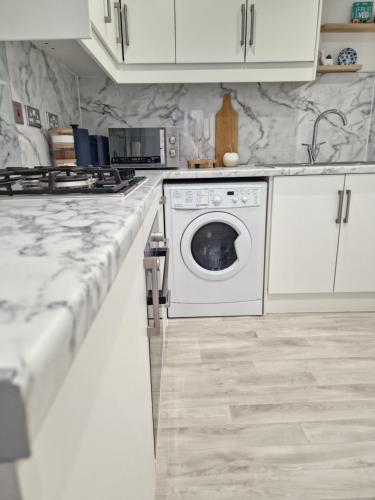 a white kitchen with a washing machine in it at Apartment Near Wembley Stadium Heathrow London Barnet Luton Airport Hendon Middlesex University - FREE Parking & WiFi - Work Contractors & Tourists Welcome in Edgware