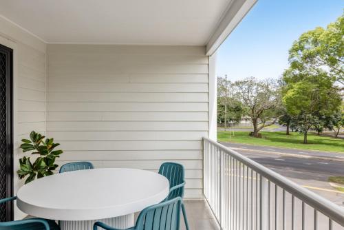 a white table and chairs on a balcony with a table at Contemporary & Convenient - City Fringe Townhouse! in Toowoomba