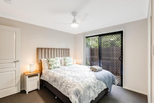 a bedroom with a bed and a large window at Contemporary & Convenient - City Fringe Townhouse! in Toowoomba