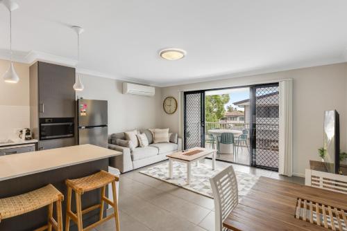 a kitchen and living room with a couch and a table at Contemporary & Convenient - City Fringe Townhouse! in Toowoomba