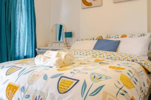 a bedroom with a bed with a comforter on it at Modern Comfort for 5 Relax, Stay & Explore in Meltham