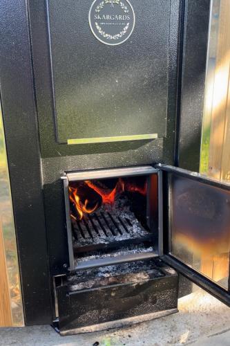 a stove with a fire inside of it at Chambre dHôtes GALET EN LIN dans Ecolodge ENTRE MER & CAMPAGNE in Octeville-sur-Mer