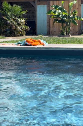 a blanket laying on the ground next to a swimming pool at Chambre dHôtes GALET EN LIN dans Ecolodge ENTRE MER & CAMPAGNE in Octeville-sur-Mer