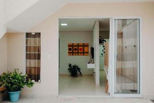 a glass door leading into a room with plants at Conforto e tranquilidade in Vitória da Conquista