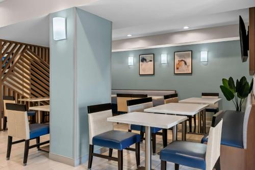 a restaurant with tables and chairs and a staircase at Best Western Executive Inn in Seagoville