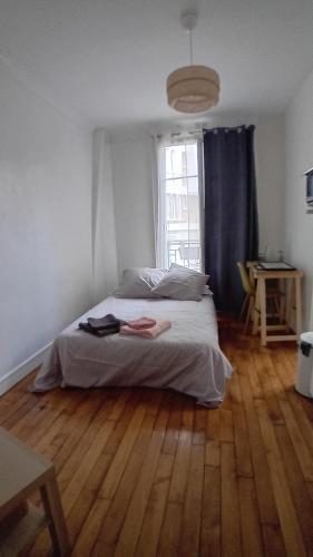 une chambre avec un lit et un parquet dans l'établissement Studio Paris 13 Quartier Butte-aux-Cailles, à Paris