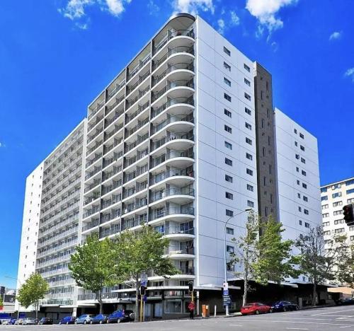 a large white building with cars parked in front of it at Aura two bedroom1 living room Wifi ,balcony, harbor view, easy parking 1404 in Auckland