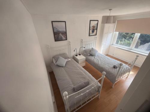 una sala de estar con dos camas y un sofá en Mitchell House, en Bellshill