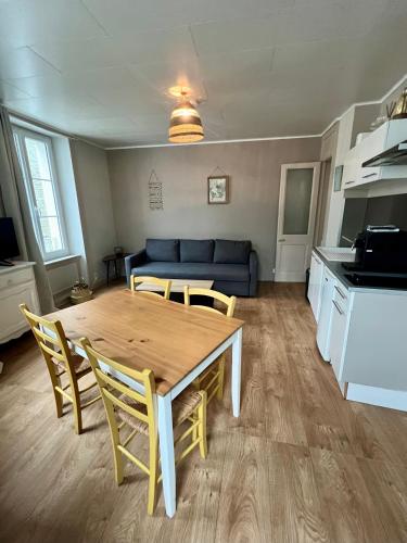 salon ze stołem i krzesłami oraz niebieską kanapą w obiekcie Escale en Ville Appart entier T2 centre ville de Cherbourg w mieście Cherbourg en Cotentin