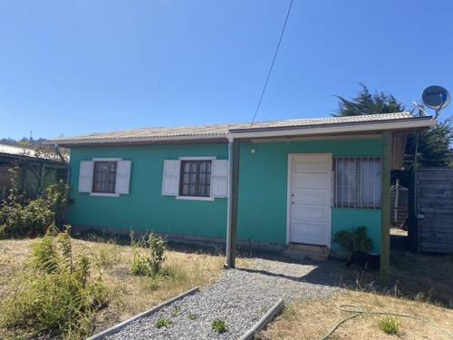 a blue house with a cat sitting outside of it at Casa equipada para 8 personas in Boca Pupuya