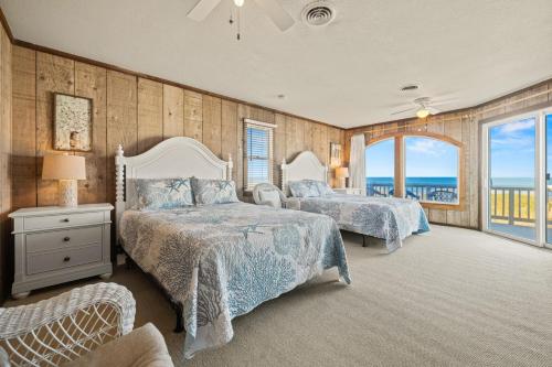 Un dormitorio con dos camas y vista al mar. en Summer Days 4 Bedroom Oceanfront Home, en Kill Devil Hills