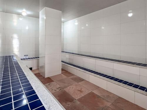 ein Badezimmer mit weiß gefliesten Wänden und blauen Fliesen in der Unterkunft Apto para temporada em Arraial D'ajuda in Porto Seguro