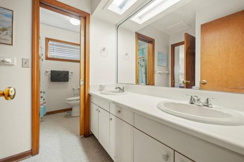 Un baño con dos lavabos y un inodoro. en Summer Nights 4 Bedroom Oceanside Home, en Kill Devil Hills