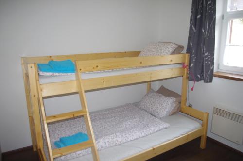 two bunk beds in a room with a ladder at Apartment Baťův Domek in Malá Morávka