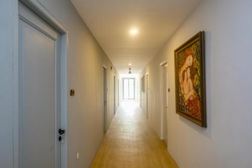 an empty hallway with a painting on the wall and a hallway sidx sidx at Urbanview Hotel JJ Bukitsari Semarang in Jatingaleh